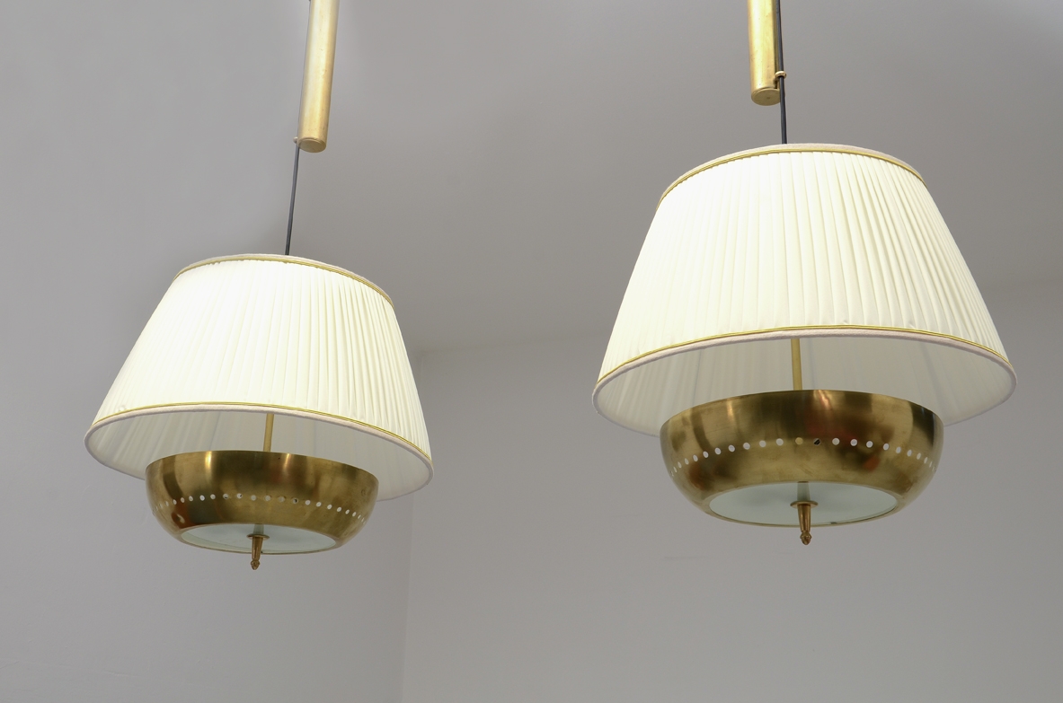 Gino Sarfatti, elegante coppia di lampade a sospensione regolabili con contappeso in ottone, piatto in ottone tornito e forato, cappello in seta, produzione Arteluce 1940ca.