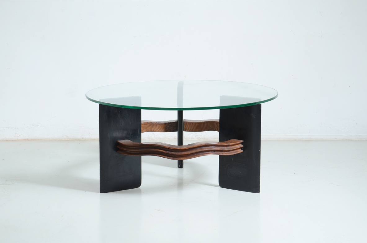 Vittorio Valabrega (1861-1952)  Coffee table with three uprights in stained wood held by a carved and wave-shaped pattern in maple wood.            Thick crystal glass top.  Valabrega Manufactory, Turin, 1940s.