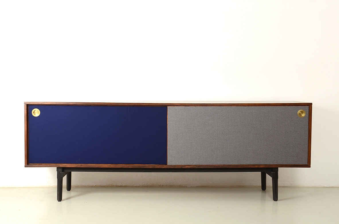 Stildomus, Sideboard in palissandro con due lunghe ante scorrevoli rivestite in panno, all'interno quattro cassetti e ripiani.  Bocchette in ottone, Italia, 1960ca.