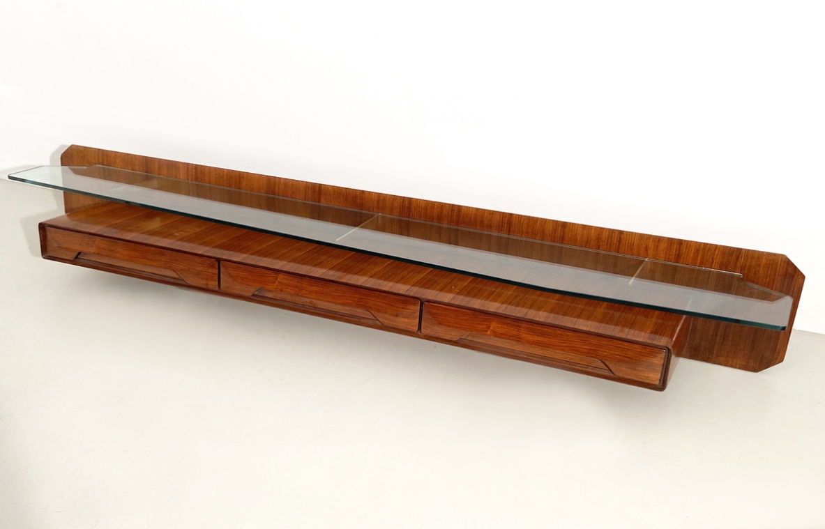 Console pensile in legno di palissandro con cristallo di grande spessore  sagomato sul fronte e su entrambe gli angoli, sospeso su tre bracci in ottone, Italia 1960ca