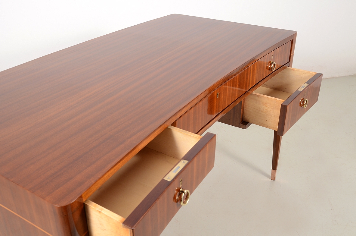 Italian elegant and curved 1950's desk in walnut and maplewood with five drawers and brass tips.