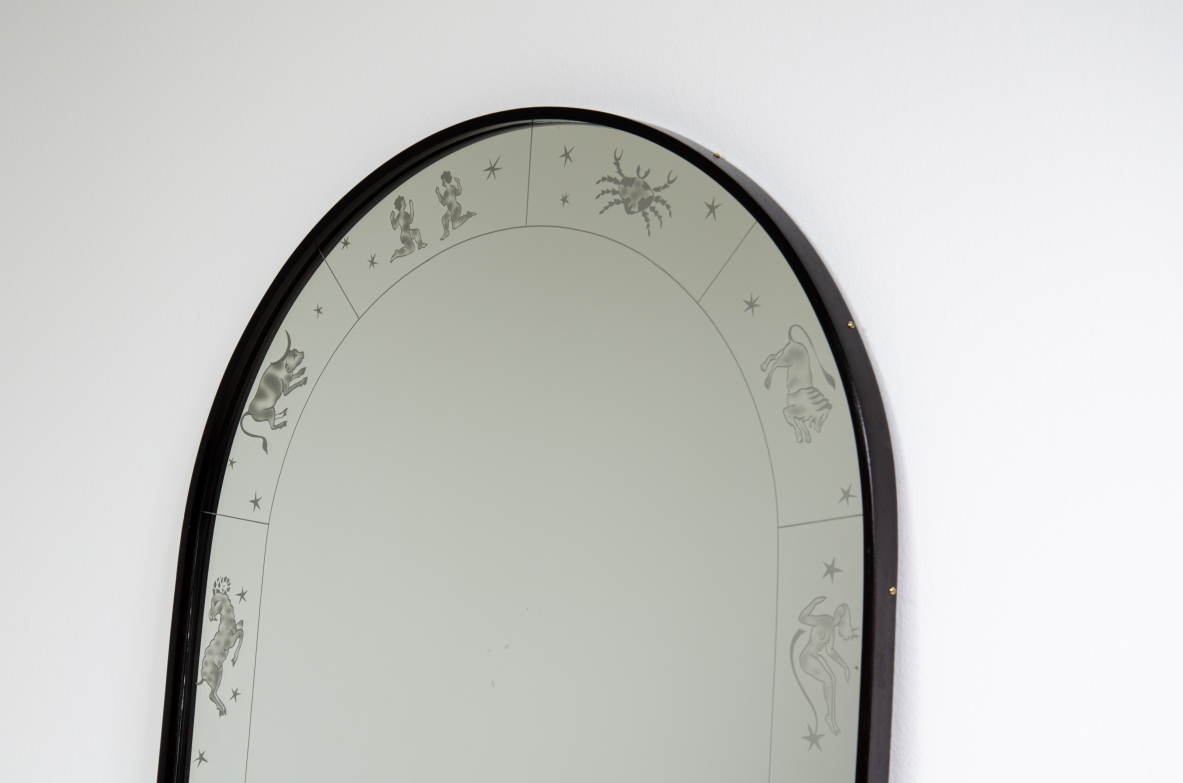 Specchiera con incisioni raffiguranti i segni dello zodiaco.  Cristallo specchiato con cornice in legno tinto. Manifattura Italiana, 1940ca.