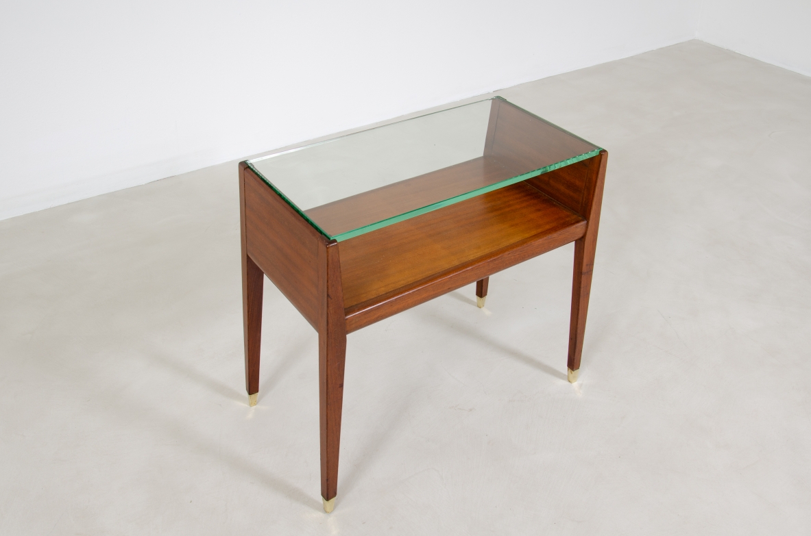 Coppia di comodini in legno con piano in cristallo e puntali in ottone. Manifattura italiana, 1950ca.
