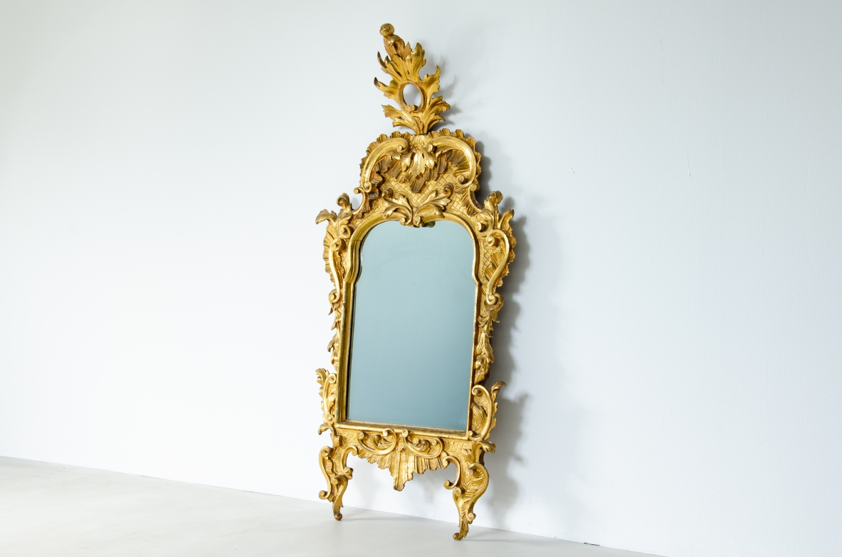specchiera intagliata e dorata a foglia d'oro zecchino con specchio a Mercurio coevo. Italia 1750 circa