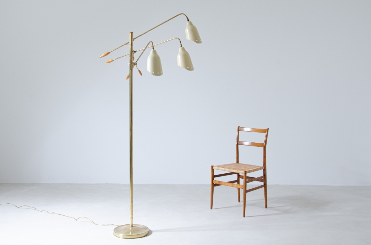 Floor lamp in brass with three adjustable arms and shaped cones in painted metal with elegant ends in turned wood.  Prod. Arredoluce, 1950's.