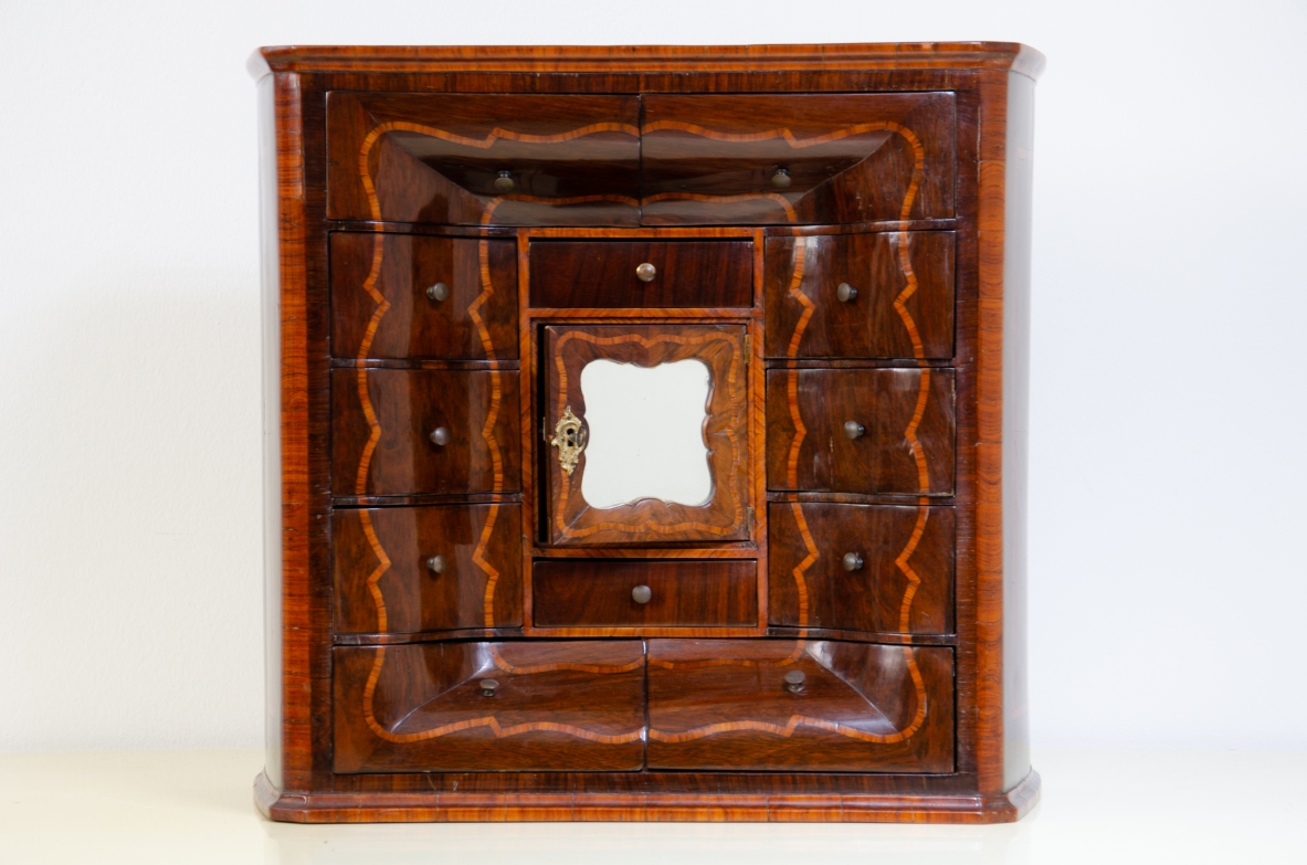 Ebanisteria genovese, 1750ca, monetiere in legno di viola filettato in legno di rosa con fronte mosso, edicola centrale con sportello sagomato e specchio centrale