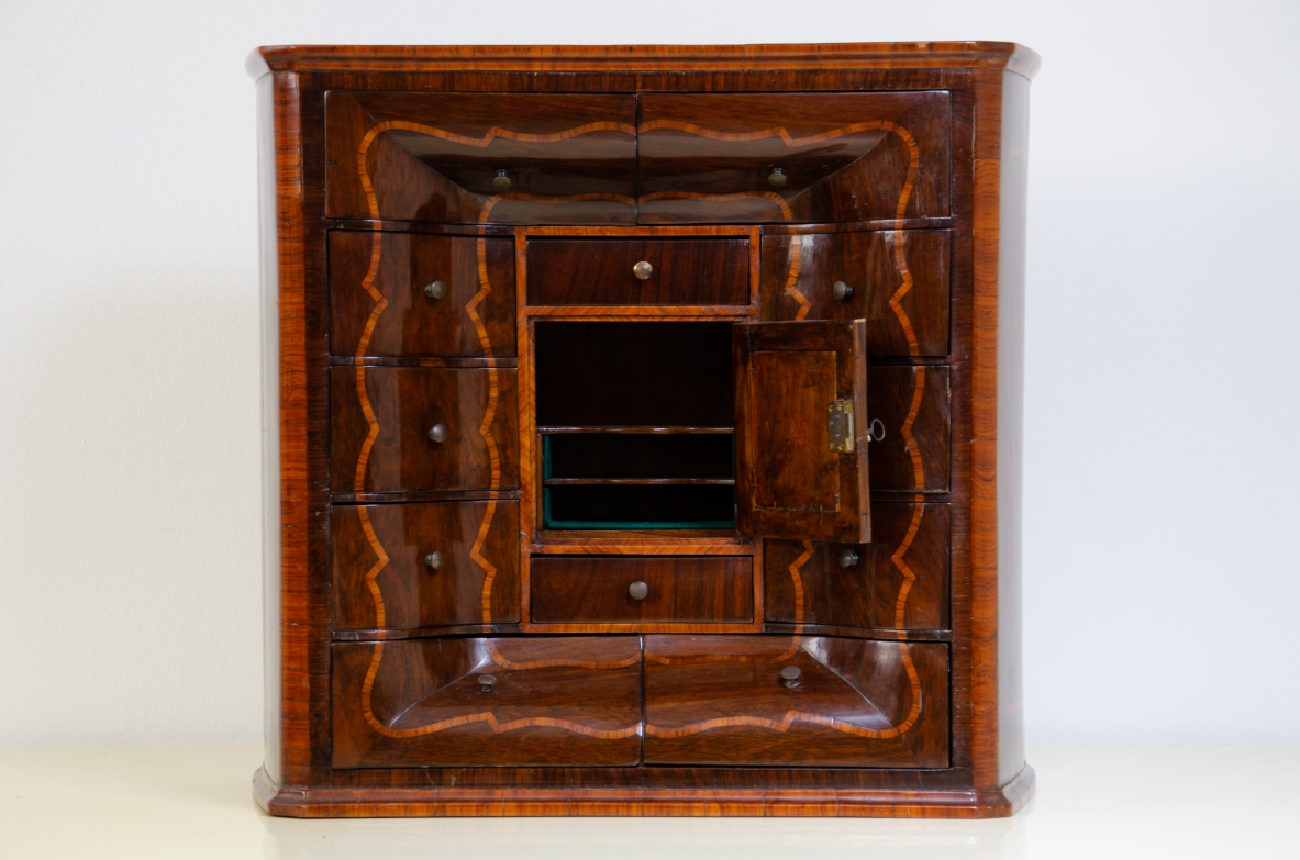Ebanisteria genovese, 1750ca, monetiere in legno di viola filettato in legno di rosa con fronte mosso, edicola centrale con sportello sagomato e specchio centrale