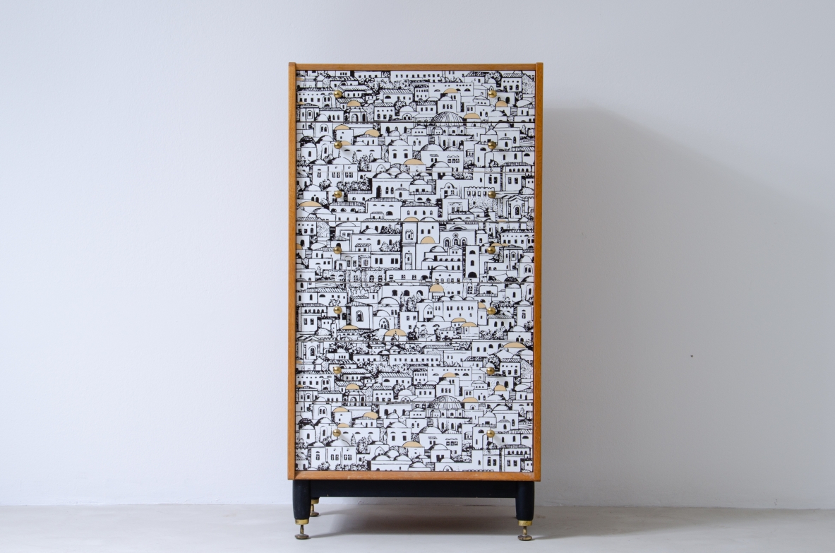 Piero Fornasetti, piccolo mobile a cassetti con fronte decorato con disegni di architetture medio orientali. Base in legno con puntali in ottone e fianchi in frassino.  Firmato Piero Fornasetti, 1950ca.
