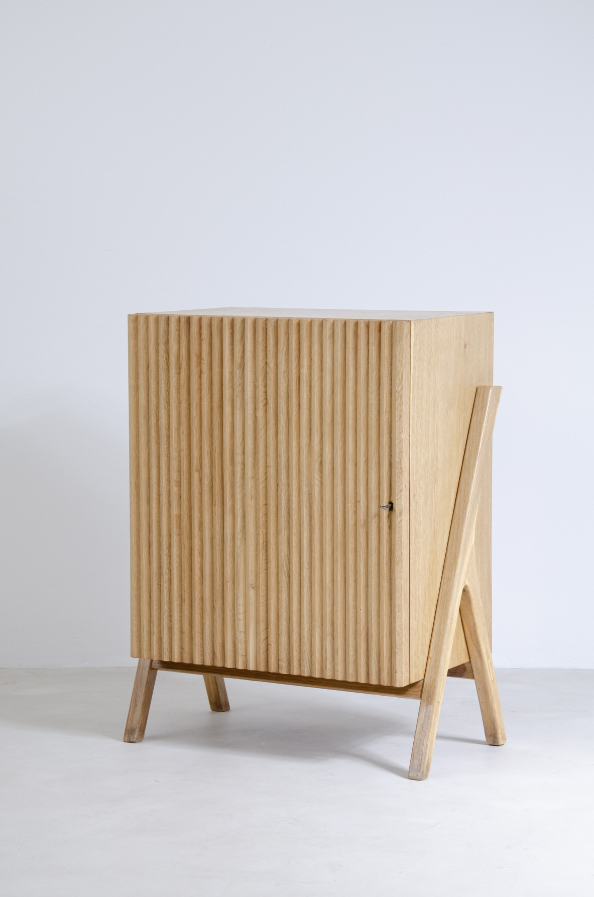 Piccolo mobile contenitore in rovere chiaro con fronte in legno cannettato.  Manifattura italiana anni 50'.