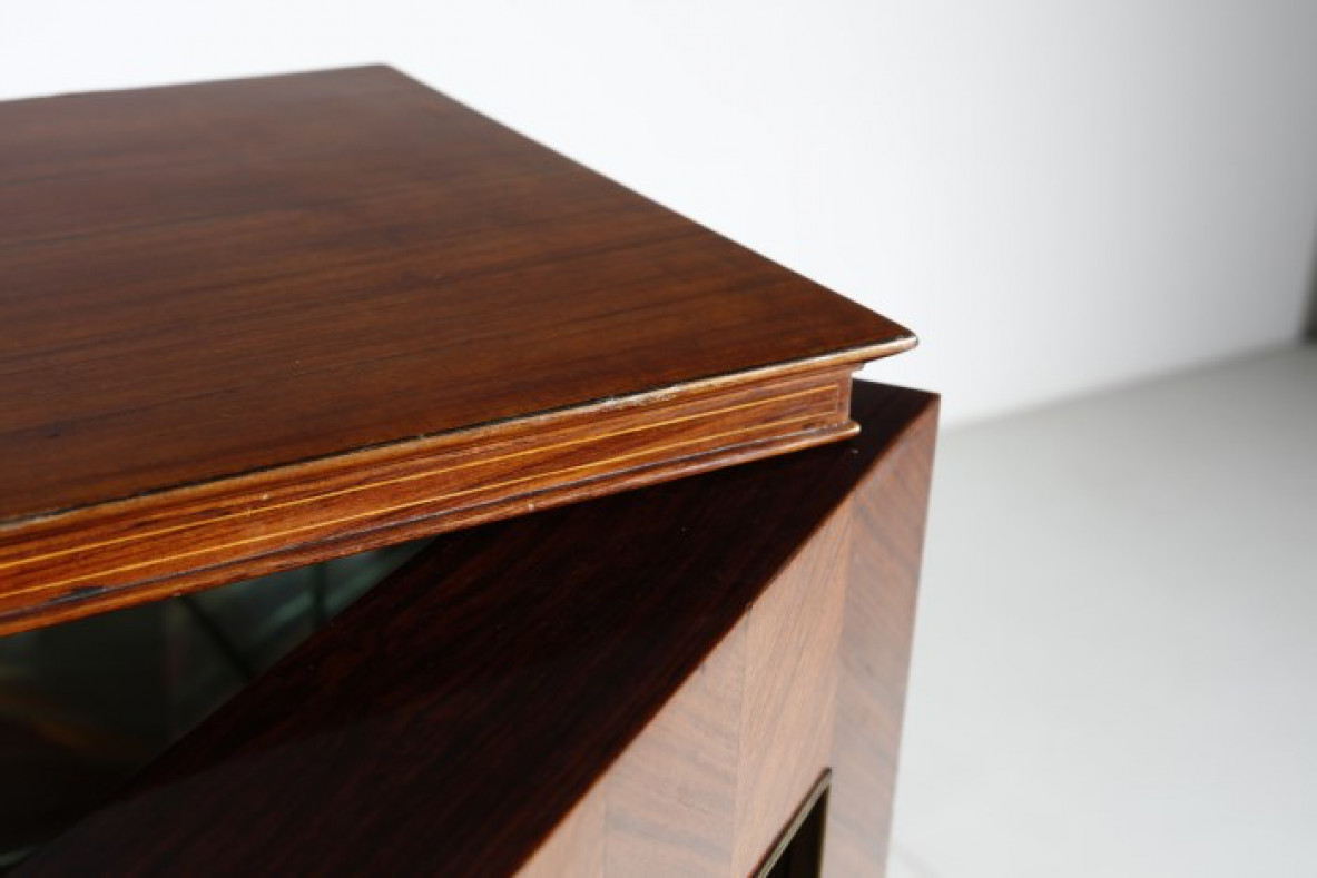 Paolo Buffa (1903-1970)  Elegante mobile bar con fronte in palissandro intarsiato e specchiature color ambra. All'interno ripiani e cassetti con scomparti e portabottiglie rivestiti in specchio. Dettagli in ottone.  Manifattura Italiana, 1940ca.