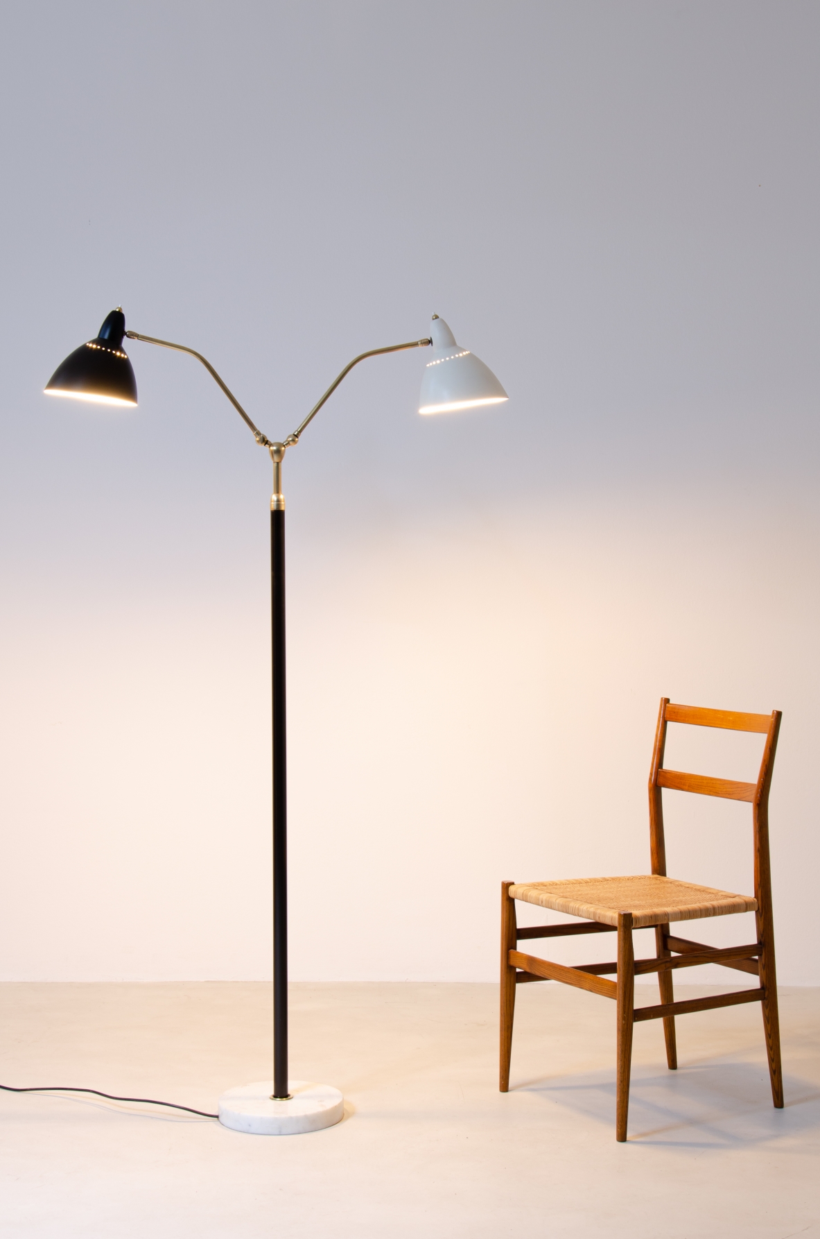 Lampada da terra con base in marmo, stelo in ottone e doppio diffusore in metallo verniciato.  Prod. Lumen, 1950ca.
