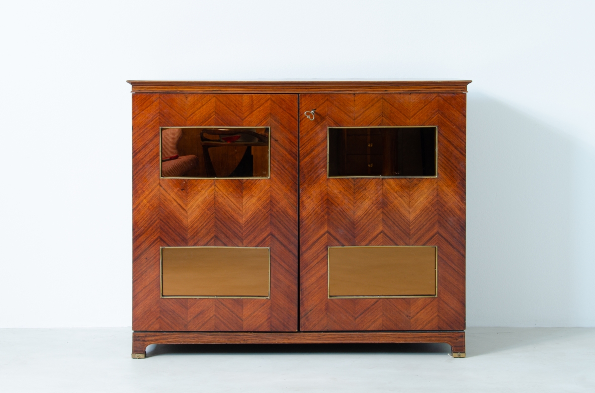 Paolo Buffa (1903-1970)  Elegante mobile bar con fronte in palissandro intarsiato e specchiature color ambra. All'interno ripiani e cassetti con scomparti e portabottiglie rivestiti in specchio. Dettagli in ottone.  Manifattura Italiana, 1940ca.