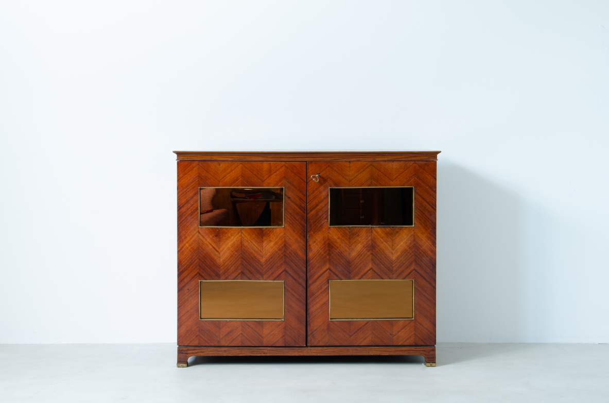 Paolo Buffa (1903-1970)  Elegante mobile bar con fronte in palissandro intarsiato e specchiature color ambra. All'interno ripiani e cassetti con scomparti e portabottiglie rivestiti in specchio. Dettagli in ottone.  Manifattura Italiana, 1940ca.
