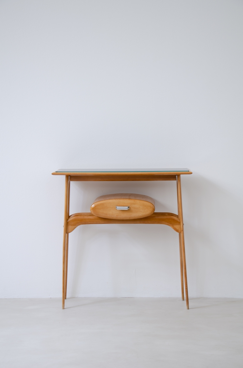 Piccola console in legno biondo con piano il vetro opaline e cassetto ovale.  Manifattura italiana 1950ca.