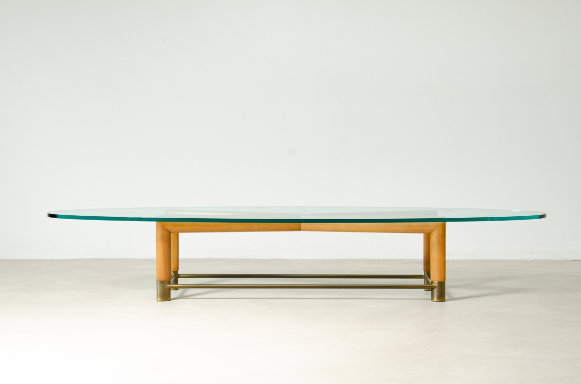 Tavolino ovale con struttura in legno, piedini in ottone e piano in cristallo molato. Manifattura italiana, 1950ca.