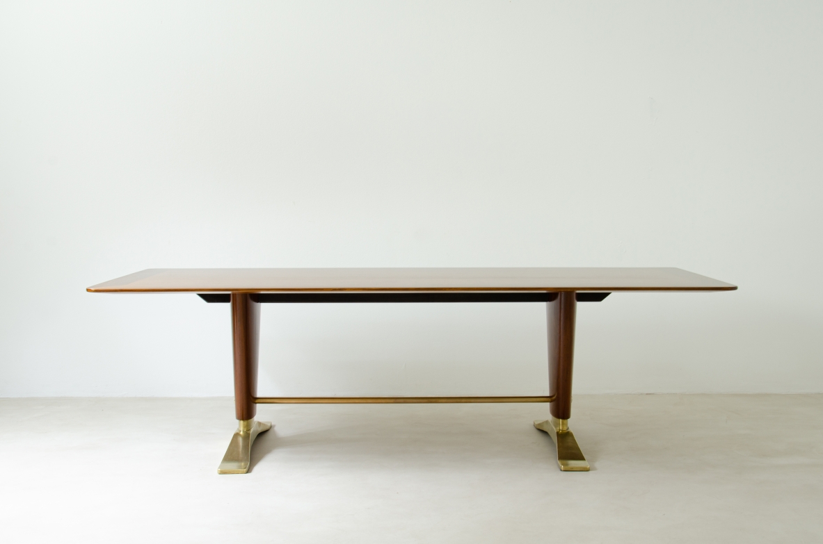 Grande tavolo in legno di noce con due montanti tenuti da traversa in ottone e importanti basamenti in fusione di bronzo.  Manifattura italiana 1940ca.