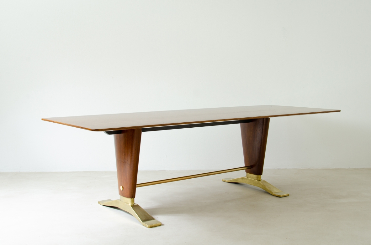 Grande tavolo in legno di noce con due montanti tenuti da traversa in ottone e importanti basamenti in fusione di bronzo.  Manifattura italiana 1940ca.