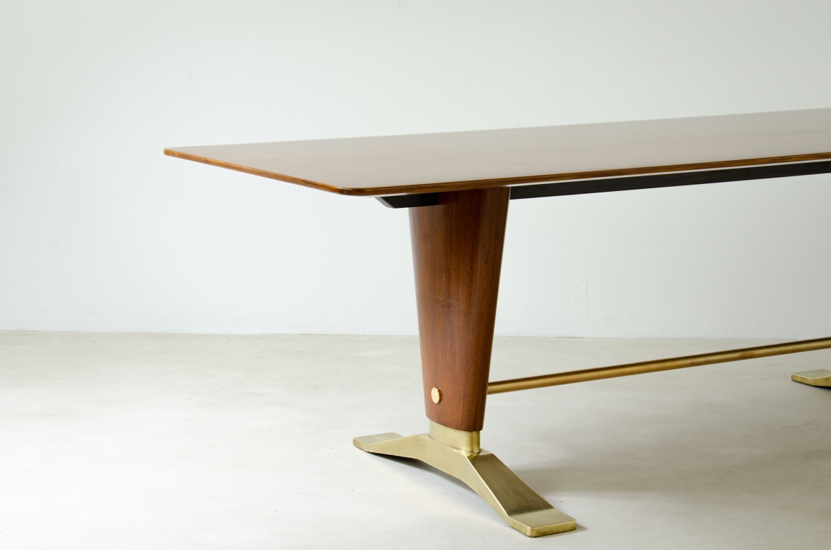 Grande tavolo in legno di noce con due montanti tenuti da traversa in ottone e importanti basamenti in fusione di bronzo.  Manifattura italiana 1940ca.