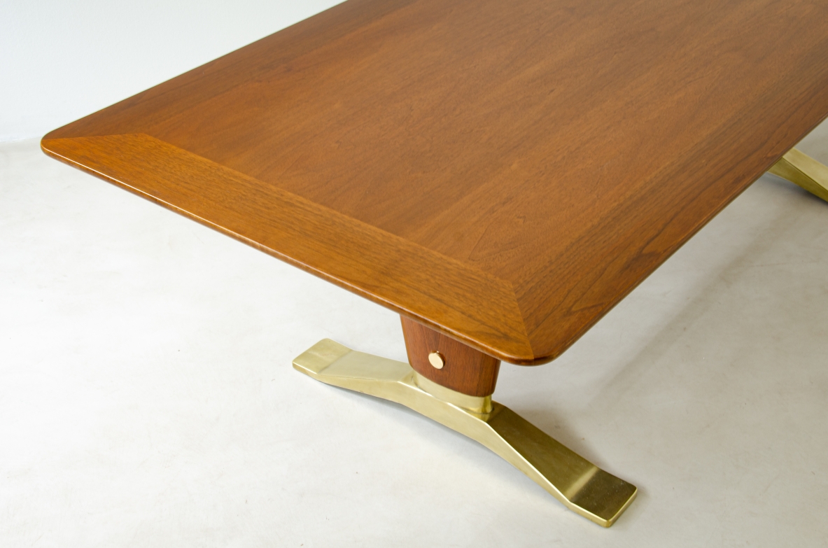 Grande tavolo in legno di noce con due montanti tenuti da traversa in ottone e importanti basamenti in fusione di bronzo.  Manifattura italiana 1940ca.