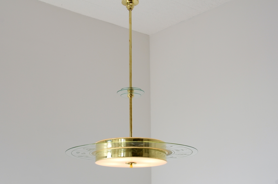 Large brass chandelier with beveled glass decorated with zodiac designs and two milky white glasses. Brass stem with three transparent bevelled glass discs.