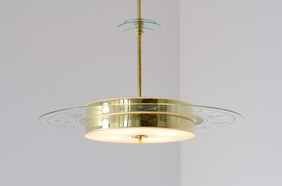 Large brass chandelier with beveled glass decorated with zodiac designs and two milky white glasses. Brass stem with three transparent bevelled glass discs.