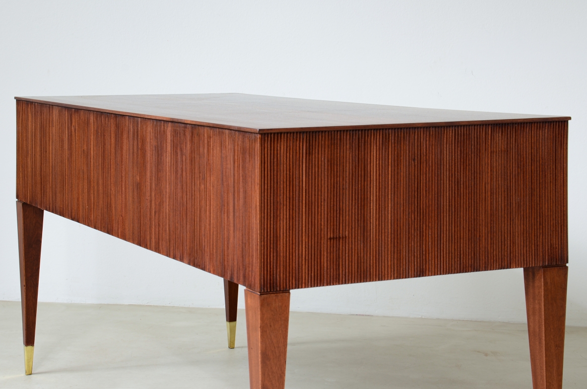 Scrivania in mogano a 4 cassetti con fronte e lati in legno grissinato,      gambe tronco piramidali con puntali in ottone.  Manifattura italiana anni 50'.