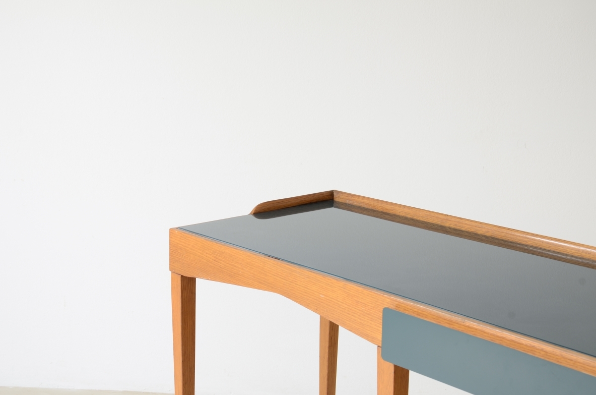 Raffinato scrittoio in rovere con piano in vetro opalino e alzatina e cassetto sagomato rivestito in polipropilene. Lunghe gambe con puntali in ottone.  Attribuzione Gio Ponti, manifattura primi anni 50.