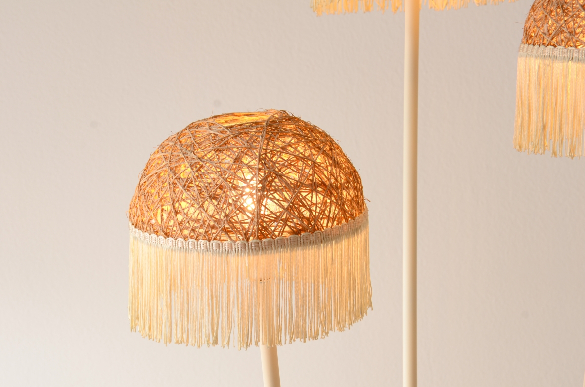 Lampada da terra a tre bracci in metallo laccato con cappelli in rattan e frange in tessuto.Manifattura italiana 1950ca.