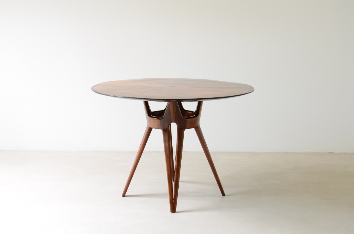 Elegante tavolo con base in legno traforato e piano lastronato.  Manifattura italiana, 1950ca.
