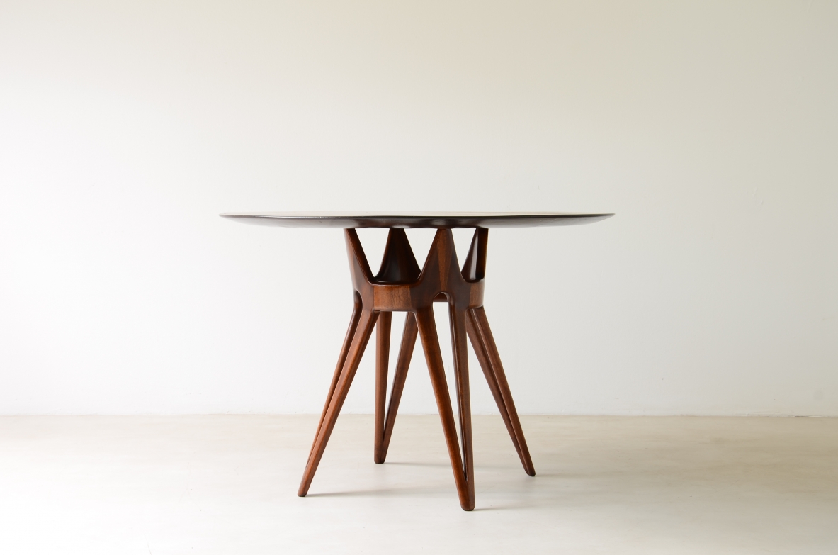 Elegante tavolo con base in legno traforato e piano lastronato.  Manifattura italiana, 1950ca.