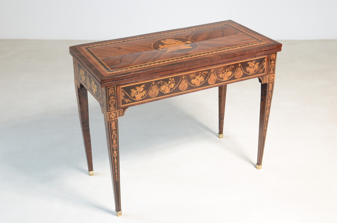 Elegante tavolino da gioco con disegni a intarsio. Interno rivestito in panno.  Manifattura lombarda, epoca Luigi XVI. 1780ca.