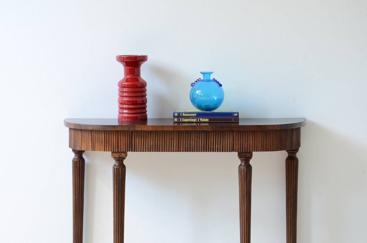 Piccola console in noce con piano curvato e fascia in legno cannettato.Manifattura italiana 1940ca.