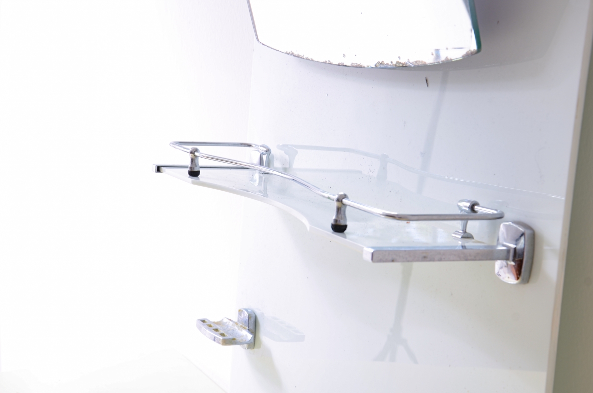Specchio da bagno in opaline bianca con specchio basculante, mensola e porta saponette in metallo cromato.  Manifattura francese, 1930ca.