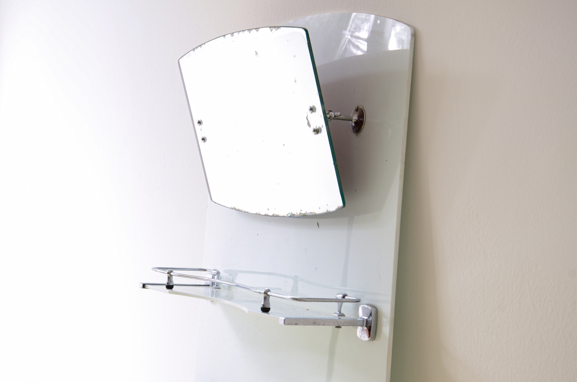 Specchio da bagno in opaline bianca con specchio basculante, mensola e porta saponette in metallo cromato.  Manifattura francese, 1930ca.