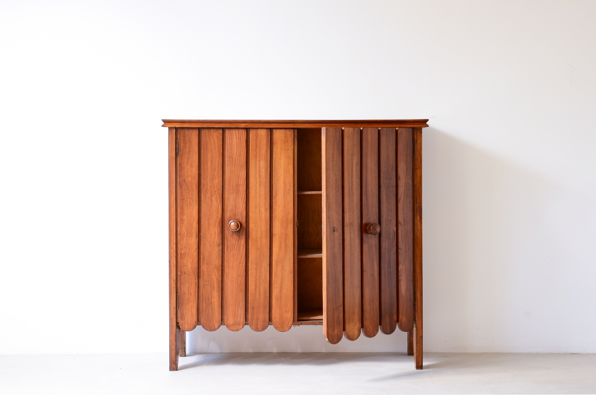 Mobile contenitore in rovere biondo con ante a doghe e motivo decorativo a onda.  Manifattura italiana anni 40ca.