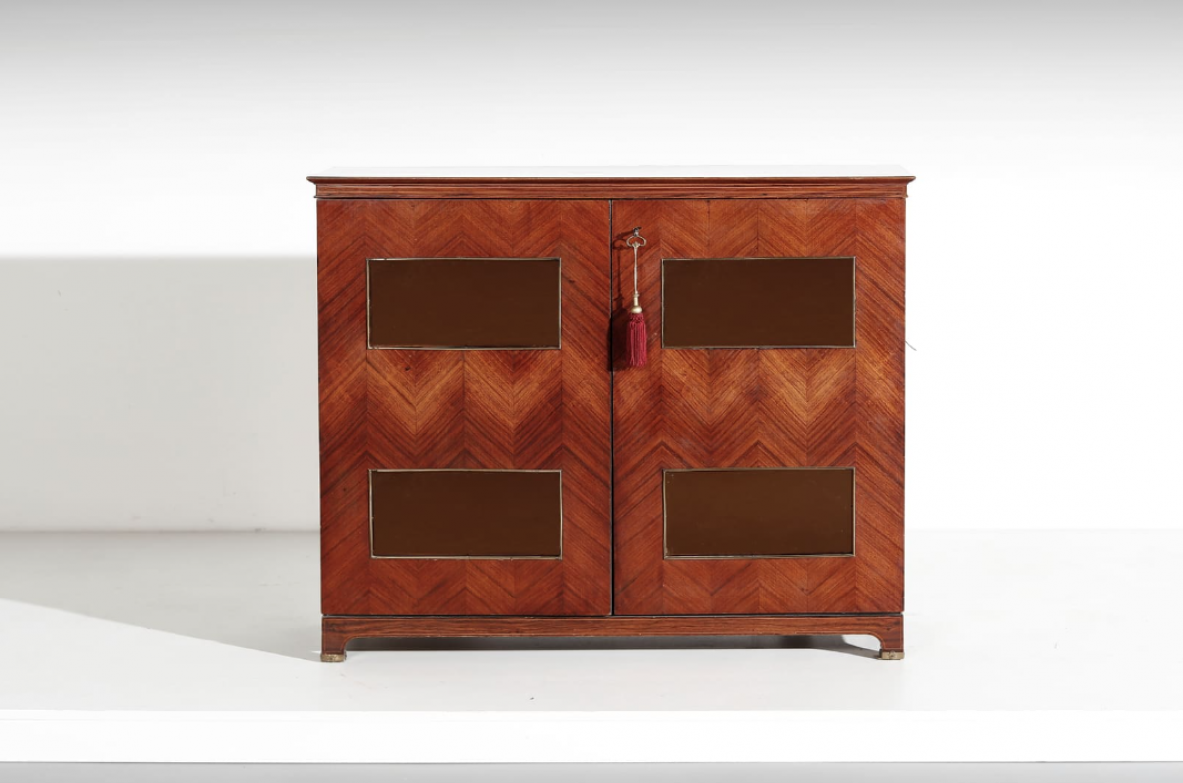 Paolo Buffa (1903-1970)  Elegante mobile bar con fronte in palissandro intarsiato e specchiature color ambra. All'interno ripiani e cassetti con scomparti e portabottiglie rivestiti in specchio. Dettagli in ottone.  Manifattura Italiana, 1940ca.