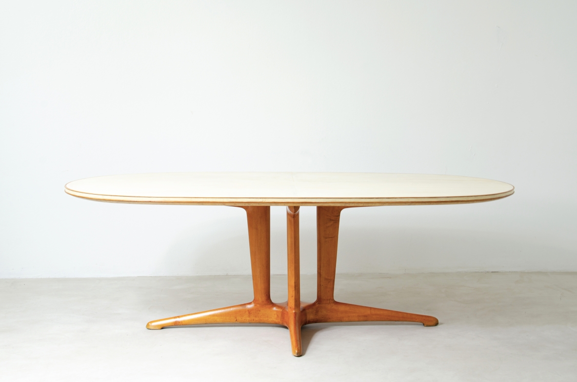 Grande tavolo con elegante struttura in legno biondo e piano rivestito in pergamena.  Manifattura italiana anni 50.