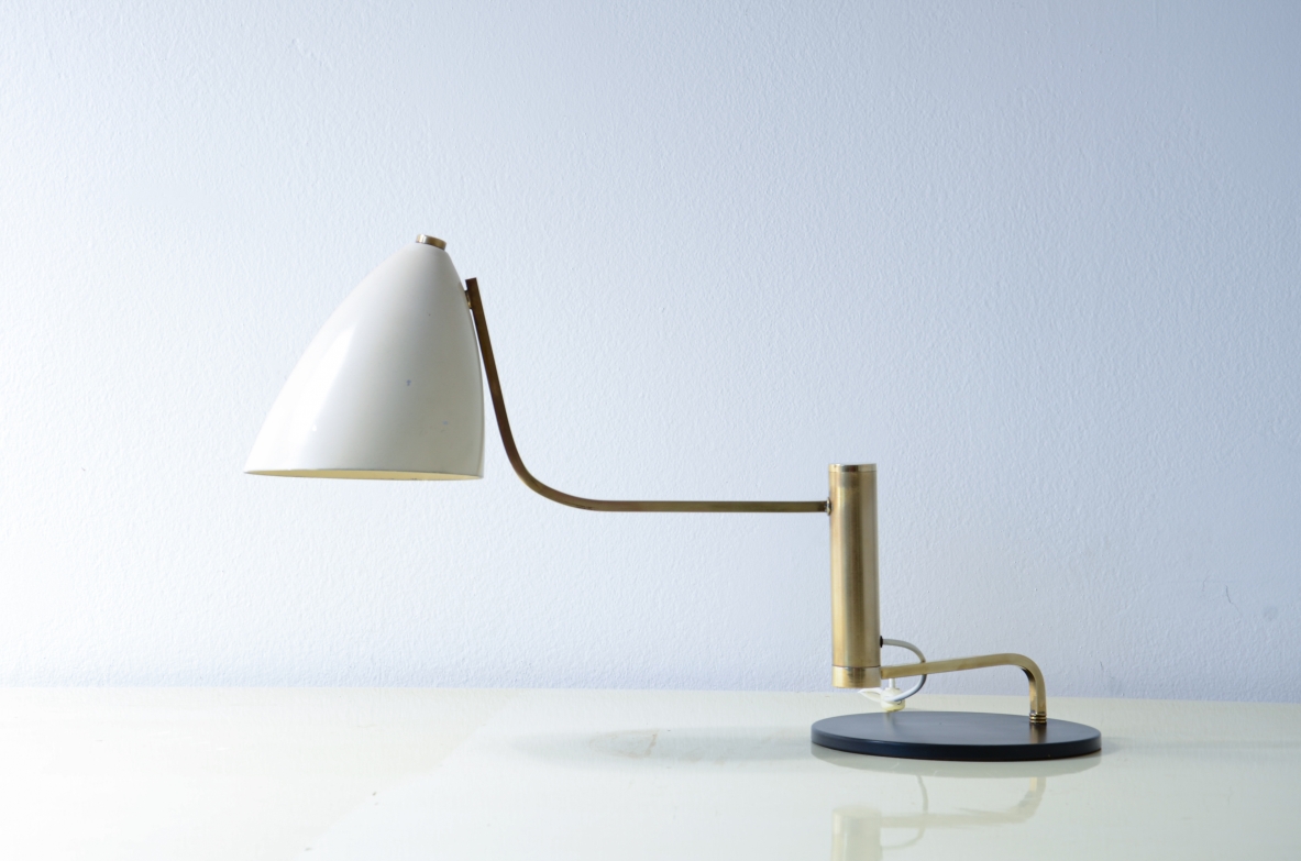 Table lamp in metal and brass with articulated arm in brass and cap in painted metal.  Italian manufacture, around 1950.