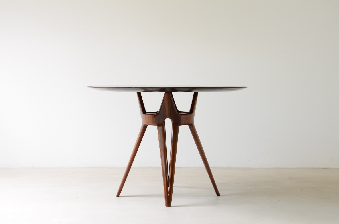 Elegante tavolo con base in legno traforato e piano lastronato.  Manifattura italiana, 1950ca.